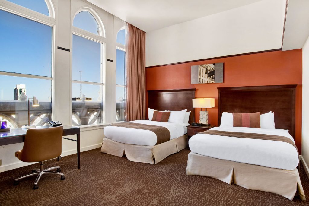 Guestroom at the Emily Morgan Hotel featuring two queen beds and a view of San Antonio.